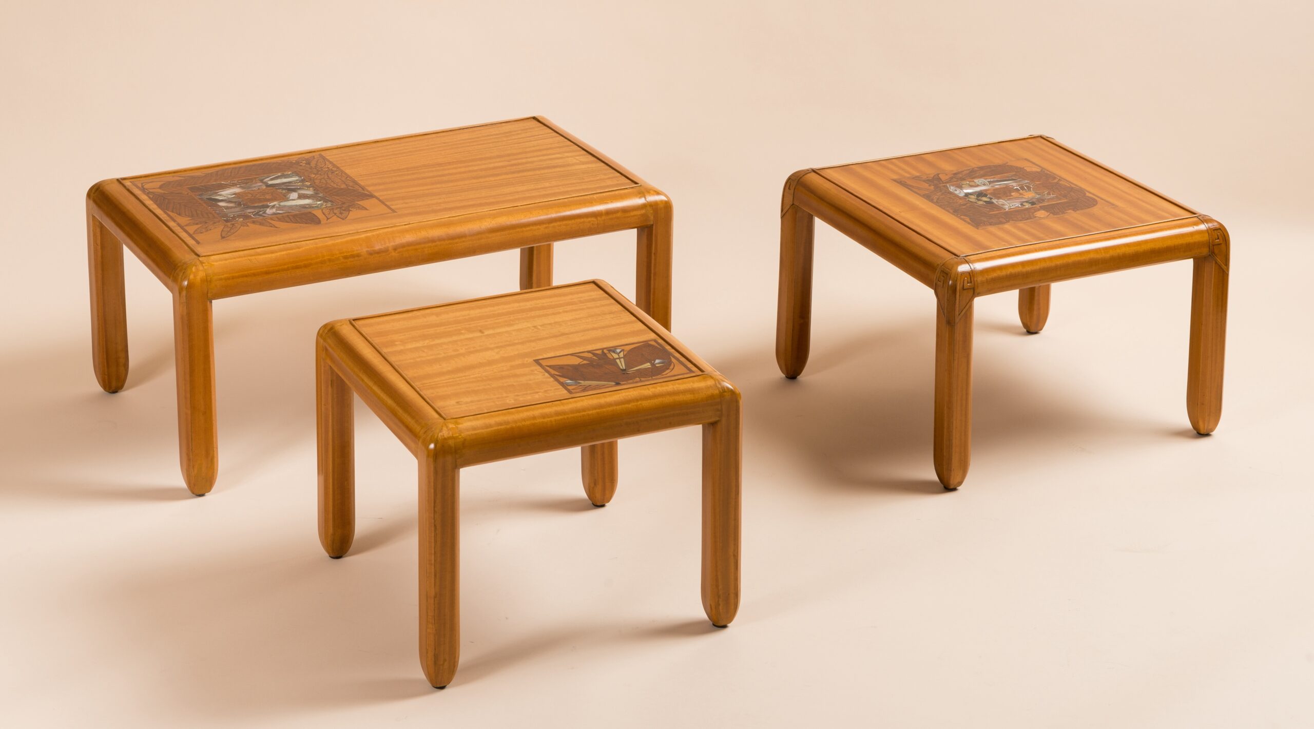 Three tables in East Indies Satinwood by Georges De Feure, c.1910. Table tops marquetry with a floral inlay, mother of pearls, ebony and fruit wood.