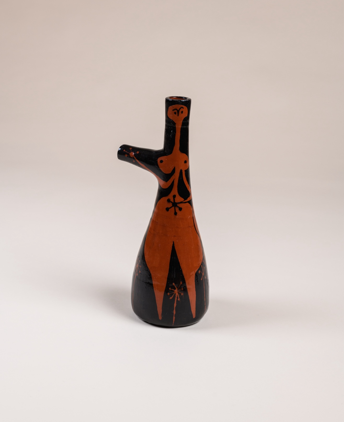 Two-necked jug by ​Valentine Schlegel and André Vilar, ​c. 1950. Orange and black glazed terracotta.​