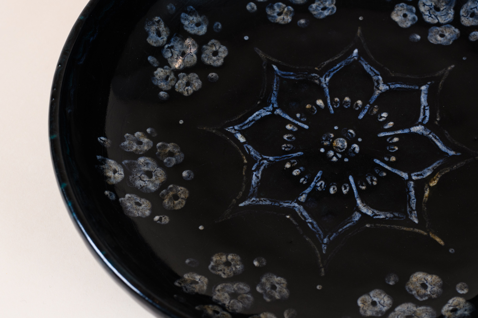 Decorated dish​ by Emile Decoeur, c.1919​. Dark blue glazed porcelain stoneware and white enamel ​decoration.